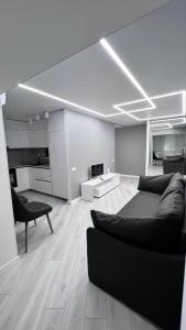 第聂伯罗Modern Gagarina Avenue的一间带黑色沙发的客厅和一间带