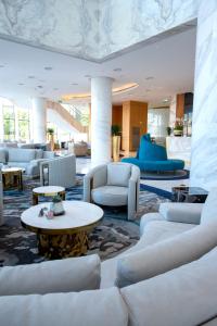 LusailCentury Marina Hotel - Lusail的大堂设有白色的沙发和桌子。