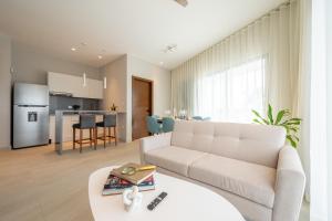 科苏梅尔Kippal - Modern Oasis - ApartHotel的客厅配有沙发和桌子