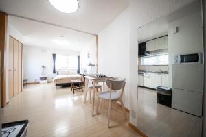 小樽Sumiyoshi House Room B的厨房以及带桌椅的起居室。