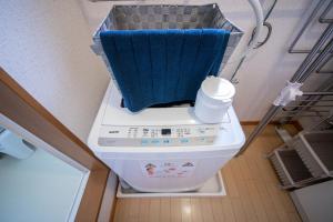 小樽Sumiyoshi House Room B的洗衣机的顶部有蓝色毛巾