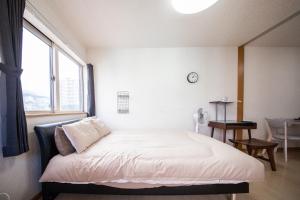 小樽Sumiyoshi House Room B的一张位于带大窗户的房间内的床铺