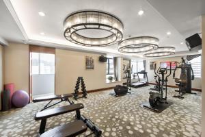 深圳The LA Hotel 新世界伟瑞酒店的一间健身房,里面设有数个健身器材