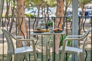 滨海阿热莱斯Appartement mignon à 100m de la plage, Argeles-sur-Mer - 3 personnes的阳台上配有一张桌子和两把椅子,并摆放着食物