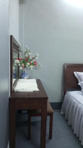 芹苴Enjoy Mekong Hostel的一间卧室配有一张带镜子的桌子和一张床