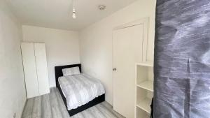 克罗伊登Aaby House in London的一间小卧室,配有床铺和白色的墙壁