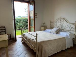 蒙特玛佐里奥梅特Valle del Metauro Country House的一间卧室设有一张大床和一个大窗户