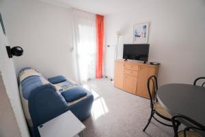萨利耶德贝阿尔恩鲁伊小屋公寓的客厅配有蓝色的沙发和桌子