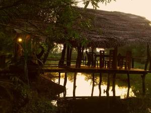 达瓦拉维Aliya Riverside & Safari Resort的水面上的一个桌子和椅子
