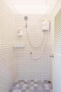合艾Lamoon Hostel的白色瓷砖浴室设有软管淋浴