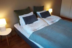赫尔辛基Cosy two rooms apartment in Helsinki的一间卧室配有一张带两盏灯的蓝色床。