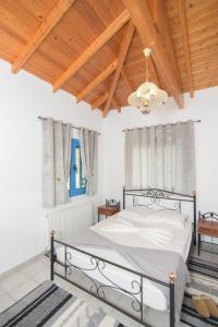 PagóndasSamian Thalia Apartment的一间卧室设有一张床和木制天花板