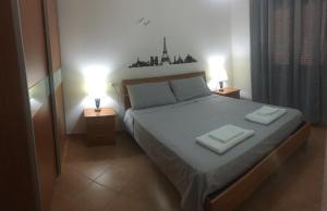 西尼斯科拉Design apartments - B的一间卧室配有一张带两盏灯的床。