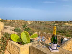 阿尔卜Villa Fieldview - Gozo Holiday Home的桌子上摆放着一瓶葡萄酒和眼镜