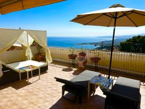 陶尔米纳Villa Greta Hotel Rooms & Suites的庭院配有遮阳伞和桌椅。