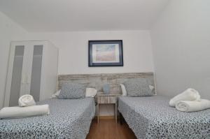 马拉加诺玛达斯精品酒店的一间设有两张床铺和枕头的客房