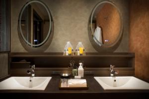 山之内町撒卡亚酒店的浴室设有2个水槽和2个镜子