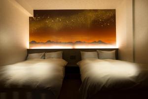 山之内町撒卡亚酒店的墙上画画的房间里设有两张床