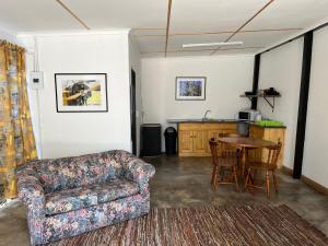 肯普顿帕克Firefly Budget Friendly Guest House的客厅配有沙发和桌子