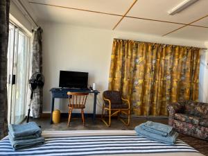 肯普顿帕克Firefly Budget Friendly Guest House的客房设有一张床、一张书桌和电视