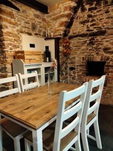 SerantesCasa Bagaro的一间带木桌和白色椅子的用餐室