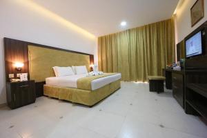 塞拉莱Samharam Resort Salalah的配有一张床和一台平面电视的酒店客房
