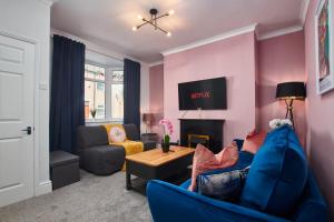 达灵顿Stunning House wParking Sleeps7的客厅设有蓝色的沙发和壁炉