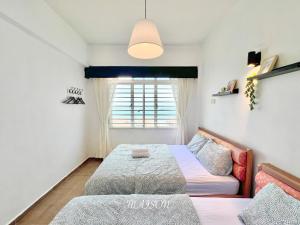 波德申Maison Seaview Suites Port Dickson的一间卧室设有两张床和窗户。