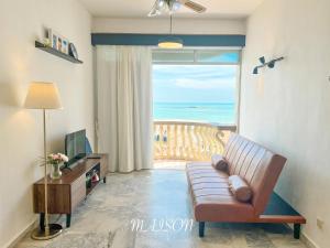 波德申Maison Seaview Suites Port Dickson的带沙发的客厅,享有海景