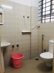 马迪凯里SERENITY GREENS的一间带卫生间、水槽和水桶的浴室