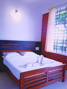 马迪凯里SERENITY GREENS的一间卧室配有一张带白色床单的床和一扇窗户。
