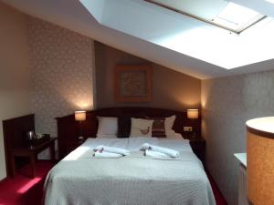 波兹南斯塔勒米亚斯托老城酒店的一间卧室配有一张床,上面有两条毛巾