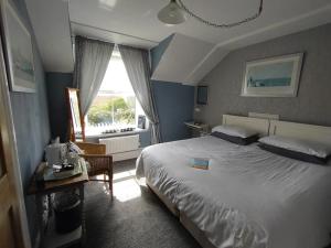 Ruan MinorChyheira的一间卧室配有一张床、一张桌子和一个窗户。