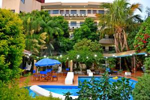 恩卡纳西翁亚瑟香巴拉酒店的一座带游泳池和椅子的酒店和一座建筑