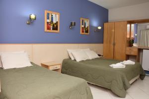 恩卡纳西翁亚瑟香巴拉酒店的紫色墙壁客房的两张床