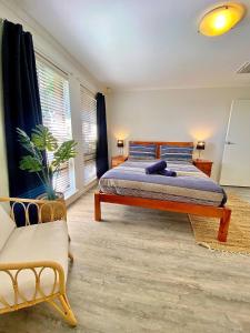 杰拉尔顿Beach front 4 x2 Home with pool的一间卧室配有一张特大号床和一张沙发