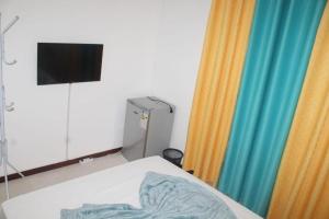 普拉亚Plateau Bedroom & Chambre - Praia Center 1的客房设有床、电视和窗帘