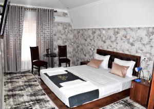 撒马尔罕Osiyo Hotel的卧室配有一张床和一张桌子及椅子