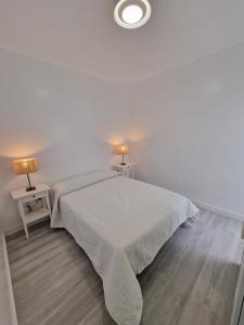 大加那利岛拉斯帕尔马斯GUANARTEME 33的白色卧室配有白色的床和两盏灯。