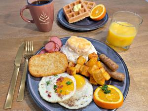 Saint ClairPINEMARK Inn Suites Events的蓝色的早餐盘,包括鸡蛋香肠和华夫饼