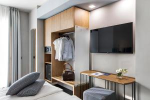 托斯科拉诺-马德尔诺Reflection Boutique Hotels的一间卧室配有一张床、一张书桌和一台电视。