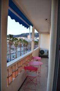 土伦Portman cosy的阳台配有粉红色的桌椅,享有海景。