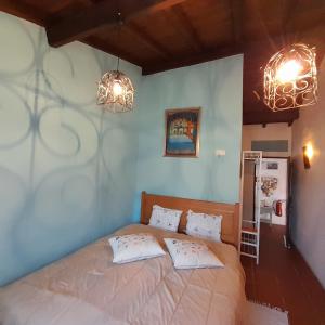 Santo António das AreiasCasa das Amoras的一间卧室配有带2个枕头和2盏灯的床