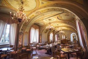 圣斯泰法诺贝尔博圣毛里齐奥雷莱斯酒店的餐厅设有带桌椅的大房间