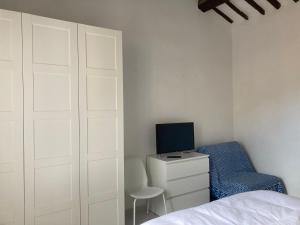 马西亚娜马里纳La casina的一间卧室配有一张床、一台电视和一把椅子