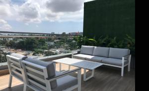 阿克拉Luxury 2 Bedroom Apartment with Huge Balcony , Pool, Gym at Tribute House的阳台配有沙发和桌椅。