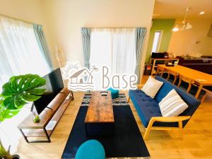 恩纳Base in Onnason,Okinanawa ウォータサーバー,本格コーヒー,アメニティと設備充実,ベビー用品,おもちゃ完備,BBQ可能的客厅配有蓝色的沙发和桌子