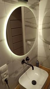 沃姆扎Underground Apartament的浴室设有白色水槽和镜子