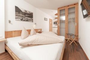 乌姆豪森Aparthotel Ambiente的卧室配有白色的床和电视。
