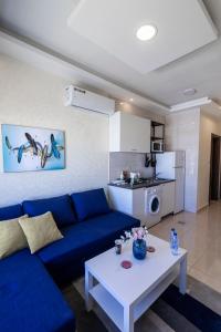 安曼Jubeiha View Apartments的客厅配有蓝色的沙发和白色的桌子